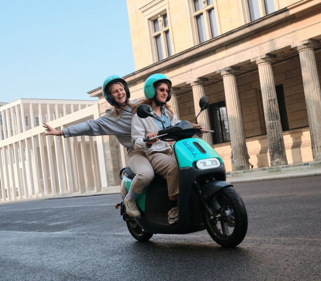 Two persons on a TIER E-Moped